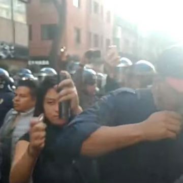 Mujer intenta quemar el rostro de un reportero durante marcha del 2 de octubre (video)
